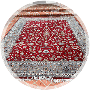 Area rug with intricate red and gray floral patterns, showcasing professional cleaning and restoration services offered by The Carpet Monkeys.