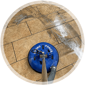 Tile and grout cleaning equipment in action, showcasing a blue Pro Force cleaning machine on tiled floor with visible cleaning solution, emphasizing professional cleaning services offered by The Carpet Monkeys.
